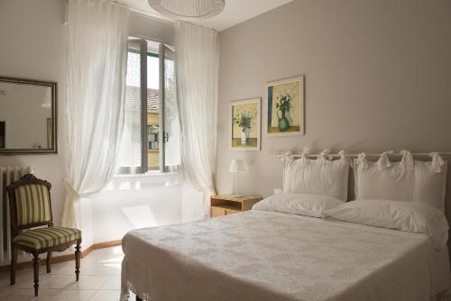 フィレンツェにあるcasa svevaのベッドルーム1室(ベッド1台、椅子、窓付)