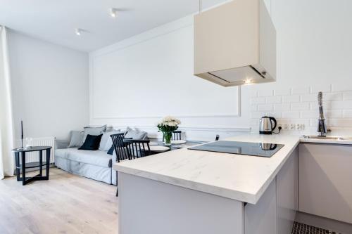 cocina y sala de estar con sofá en Elite Apartments Marine Mila Baltica, en Gdansk