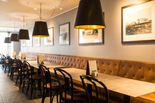 a row of tables and chairs in a restaurant at Home Hotel Uman in Umeå