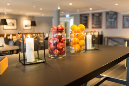 two jars of fruit and candles on a table at Home Hotel Uman in Umeå