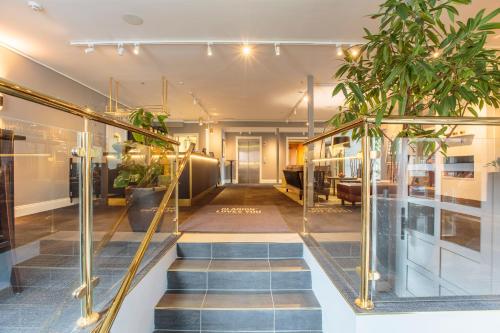 a lobby with stairs and potted plants at Home Hotel Uman in Umeå
