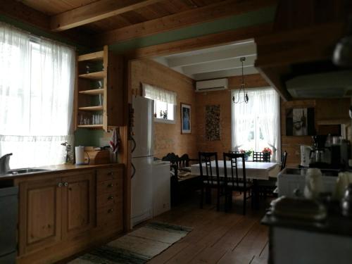 a kitchen with a white refrigerator and a dining room at Dønhaug Gjestegard in Uskedalen