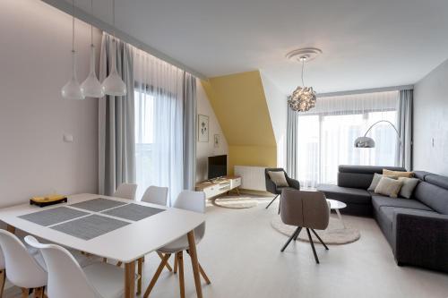 a living room with a table and a couch at GRANO APARTMENTS Gdańsk Motława SPA & Wellness in Gdańsk
