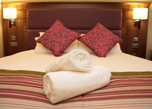 a bed with a pile of towels and pillows at Woodlands Hotel, BW Signature Collection in Dundee