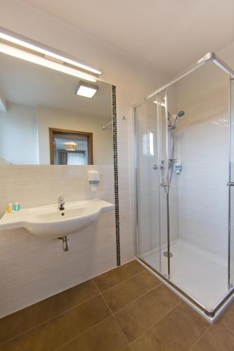 a bathroom with a sink and a shower at Pensjonat Łysica Wellness & Spa in Święta Katarzyna