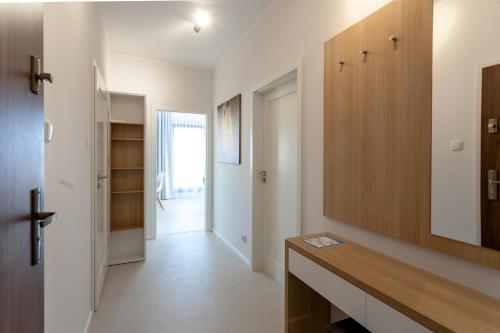 a kitchen with a counter and a hallway with a door at GRANO APARTMENTS Gdańsk Motława SPA & Wellness in Gdańsk
