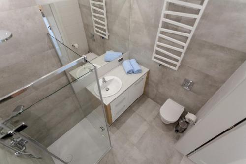 a bathroom with a sink and a shower and a toilet at GRANO APARTMENTS Gdańsk Motława SPA & Wellness in Gdańsk