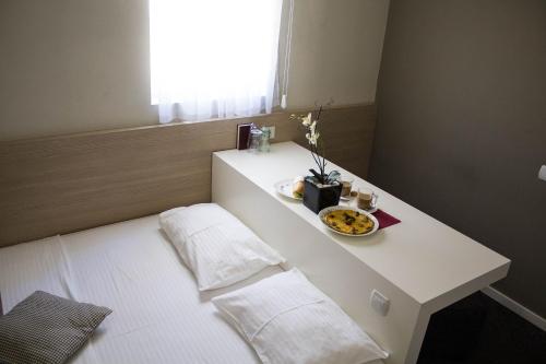 uma mesa branca com um prato de comida em Garni Hotel Krevet&Dorucak em Niš