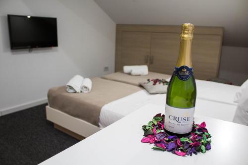 een fles wijn op een tafel in een hotelkamer bij Garni Hotel Krevet&Dorucak in Niš