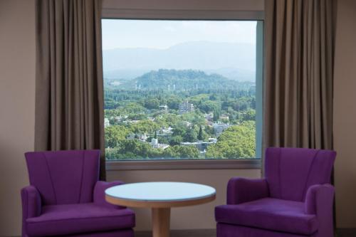 two purple chairs and a table in front of a window at DiplomaticHotel in Mendoza