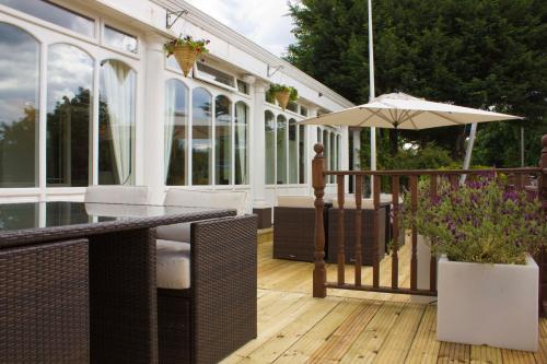 a deck with a table and an umbrella at The Falcon Hotel in Farnborough