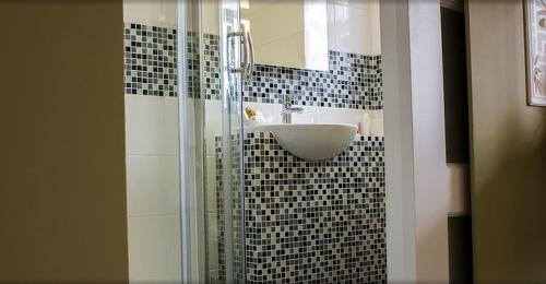 a bathroom with a sink and a glass shower at The Falcon Hotel in Farnborough