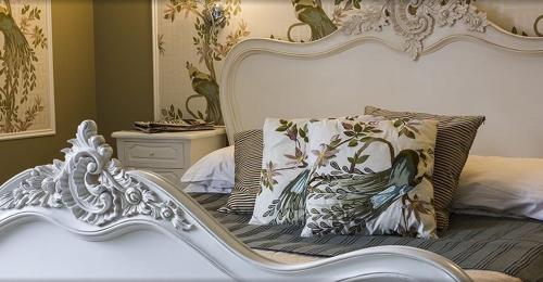 a bed with a white bed frame and a pillow at The Falcon Hotel in Farnborough