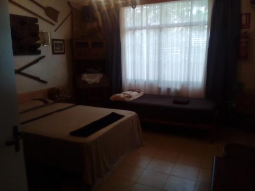 a room with a window with a bed and a window seat at Residencia Santiago Mallorca in Cala Figuera