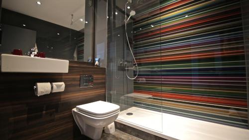 a bathroom with a toilet and a glass shower at Village Hotel Birmingham Dudley in Dudley
