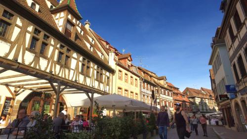 a group of people walking down a street with buildings at VVF Plaine d'Alsace Obernai Strasbourg in Obernai