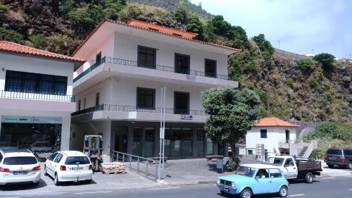 una vecchia auto blu parcheggiata di fronte a un edificio di Ape Esquerdo a São Vicente