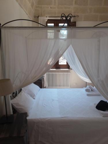a bedroom with a white bed with a canopy at Villa Pardonise- Puglia-Salento-Casa vacanze in Diso