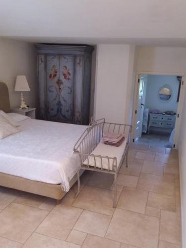 a bedroom with a bed and a bench in it at Villa Pardonise- Puglia-Salento-Casa vacanze in Diso