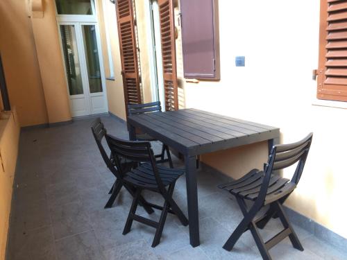 a wooden table and four chairs in a room at Palazzo di Città in Saluzzo