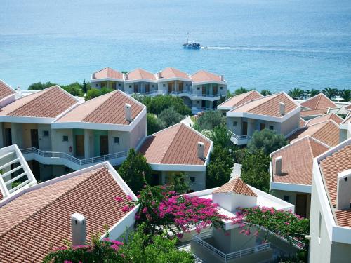 a row of houses with a boat in the water at Proteas Blu Resort in Pythagoreio