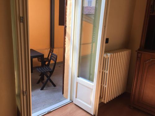 a door to a room with a chair and a table at Palazzo di Città in Saluzzo