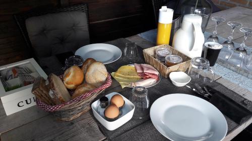 a table with a basket of bread and eggs on it at Bed & Breakfast De Schans in Makkum