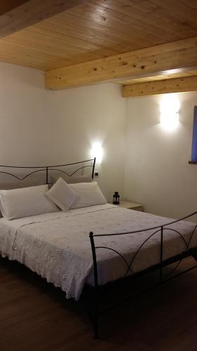 una camera da letto con un letto con lenzuola bianche e un soffitto in legno di Agriturismo al Monte a San Piero in Bagno