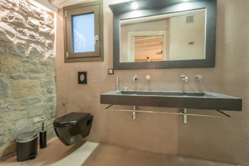 een badkamer met een wastafel en een toilet bij ARMONIA 1 & 2 in Mirina
