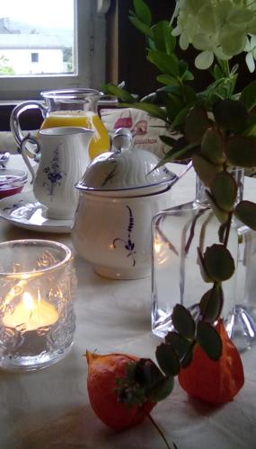 a table with a candle and a vase with a plant at Wohnen im Burghotel in Lorch am Rhein