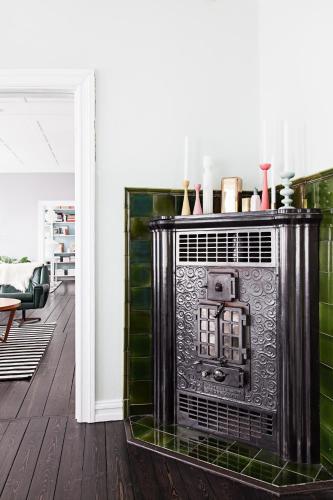 a fireplace in a living room with green tiles at Historic Villa in Downtown Reykjavik in Reykjavík