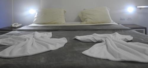 a bed with white sheets and pillows on it at Sonia Flats 214 - Flat privado no Apart Hotel Pipa's Bay in Pipa