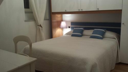 サンレモにあるVilla Monteggiaのベッドルーム(青い枕の大きな白いベッド付)