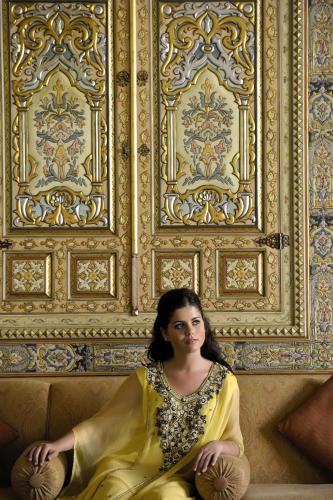 a woman sitting on a couch in front of a wall at Mövenpick Resort Petra in Wadi Musa