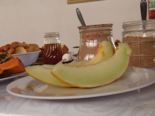 a plate with a banana on a table with bread at Hotel Miranelli in Barbacena