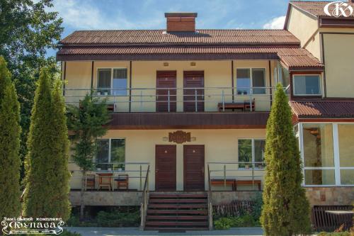 a large house with a balcony and trees at Hotel Complex Kupava in Podvorki