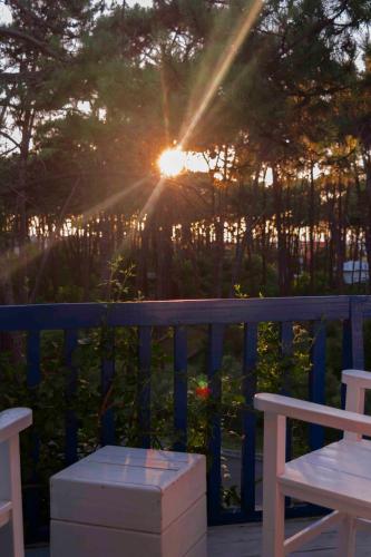 a sun setting on a blue fence with a bench at Kalá Hotel Boutique in Punta del Este