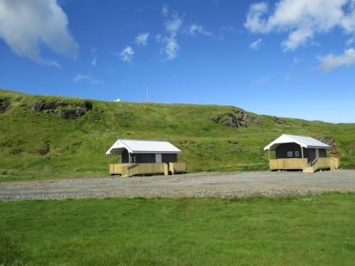 two small buildings sitting on a grassy hill at Lækjaborgir Guesthouse in Kálfafell