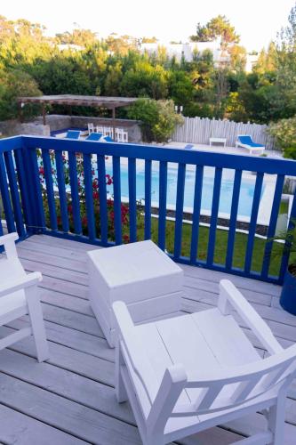 a deck with white benches and a blue fence at Kalá Hotel Boutique in Punta del Este