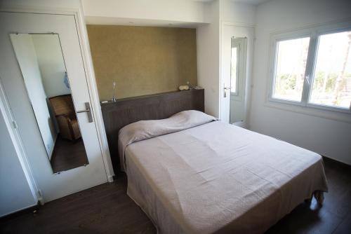 a small bedroom with a bed and a mirror at Résidence Villa Nova in Tiuccia