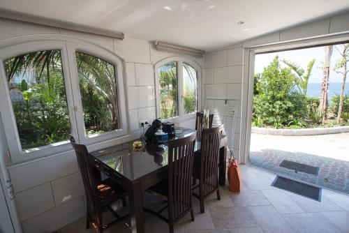 a kitchen with a table and chairs and windows at Résidence Villa Nova in Tiuccia