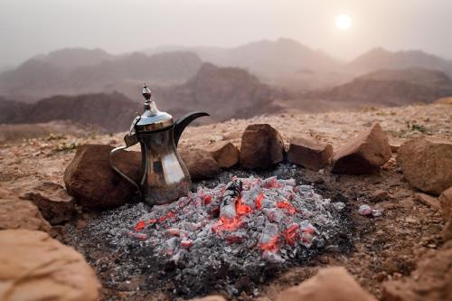 a tea kettle is sitting over a camp fire at Mövenpick Resort Petra in Wadi Musa