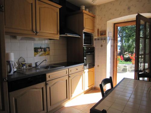 a kitchen with wooden cabinets and a table with a tableablish at La Maison de Mireille in Le Puy en Velay