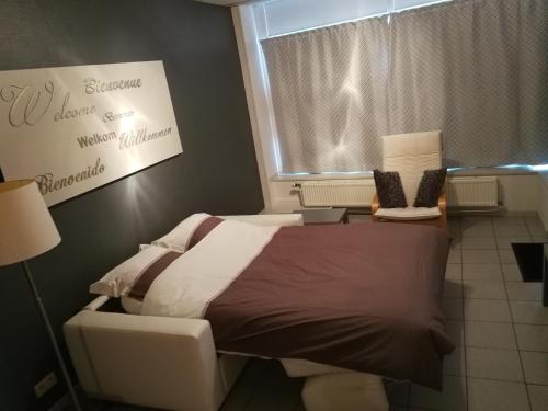a bedroom with a bed and a sign on the wall at La clé des vacances in Stavelot