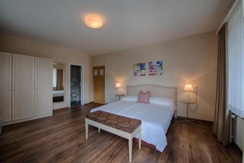 a bedroom with a large white bed with pink pillows at Hotel Neufeld in Zürich