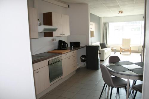 a kitchen and dining room with a table and a dining room at La clé des vacances in Stavelot