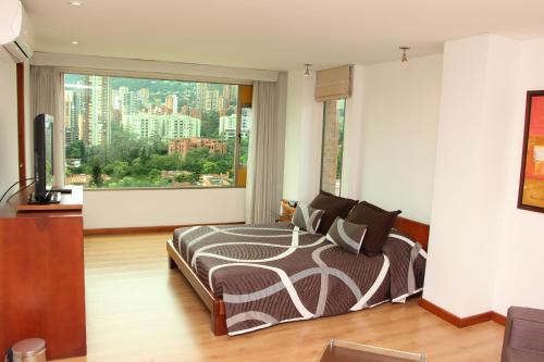 1 dormitorio con cama y ventana grande en Hotel Casa Victoria en Medellín