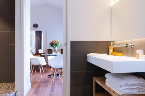 La salle de bains est pourvue d'un lavabo blanc et d'une table. dans l'établissement LOFT luxe hyper centre: terrasse/piscine/ salle de sport, à Bordeaux