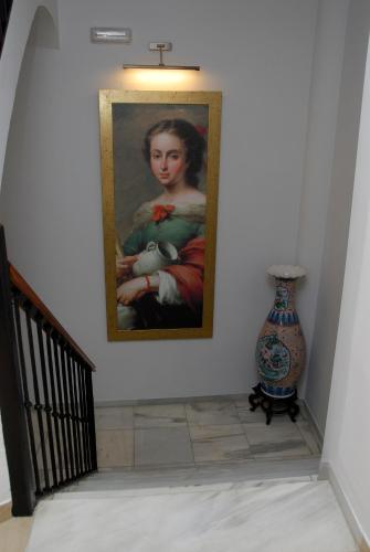 a painting of a girl on a wall next to a vase at Hotel Goya in Seville
