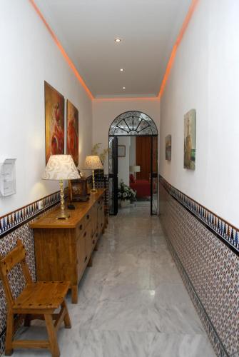 a hallway with a table and a lamp on a desk at Hotel Goya in Seville